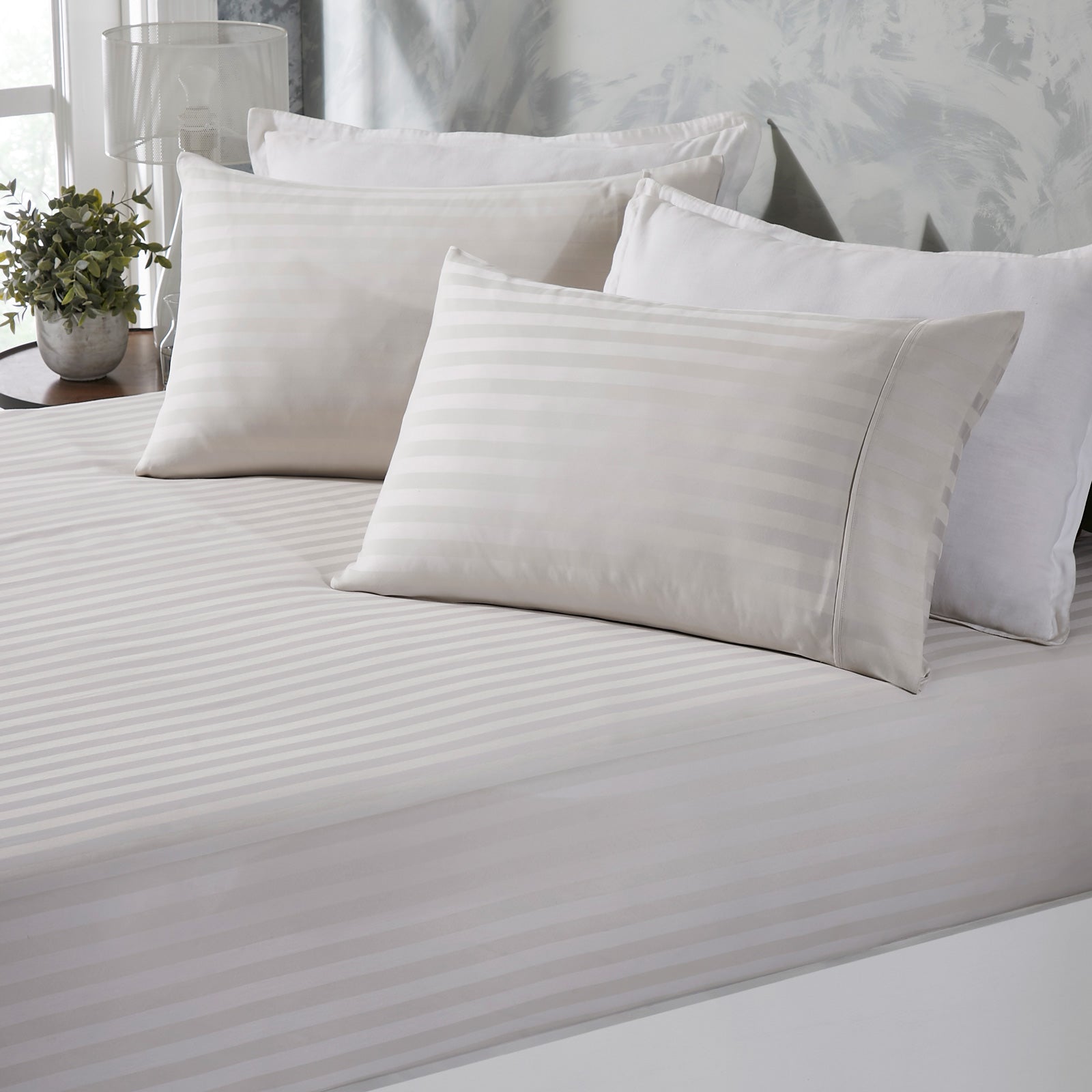 Striped sheets and pillows on bed.